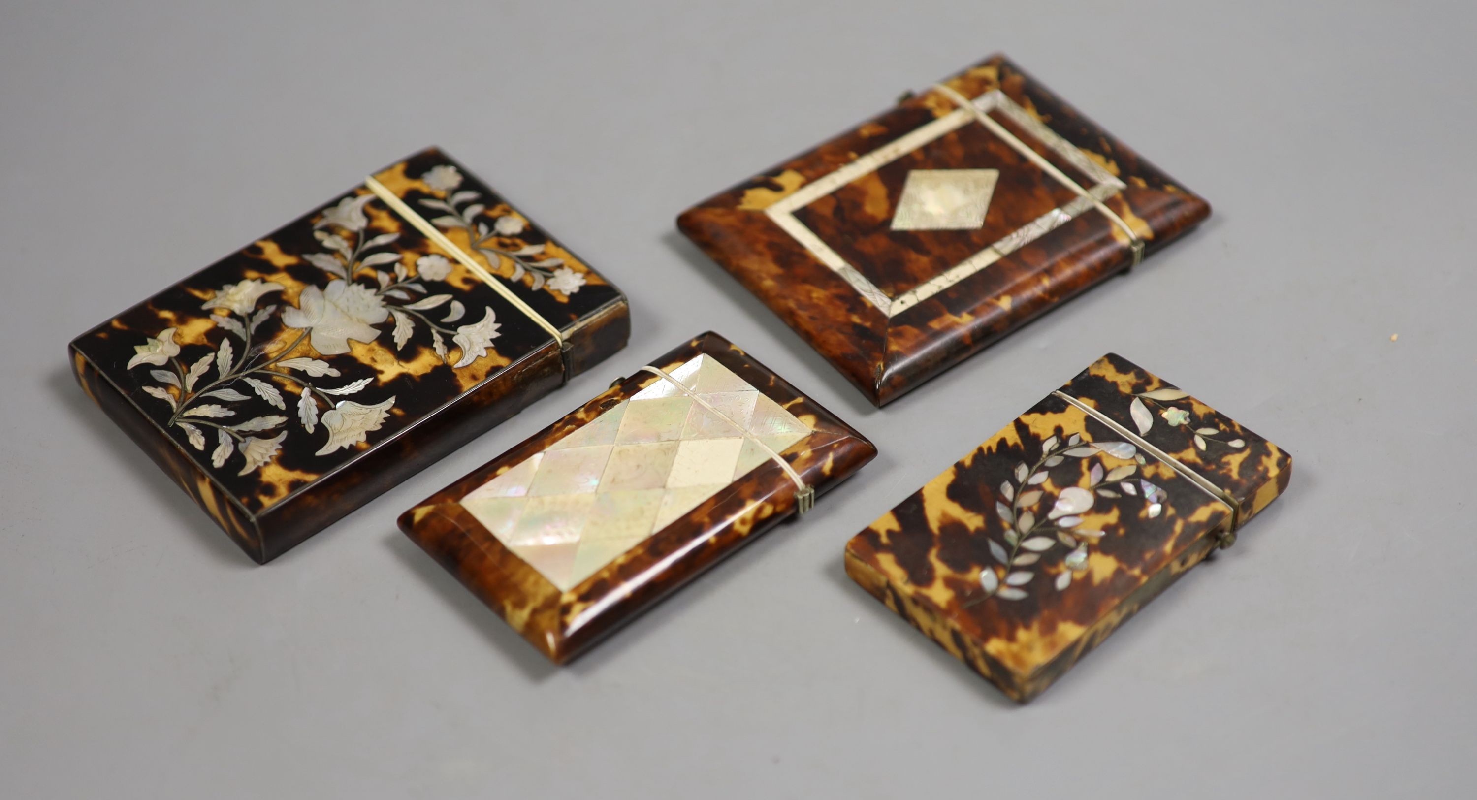 Four Victorian tortoiseshell and mother of pearl card cases, largest 10.5 cm